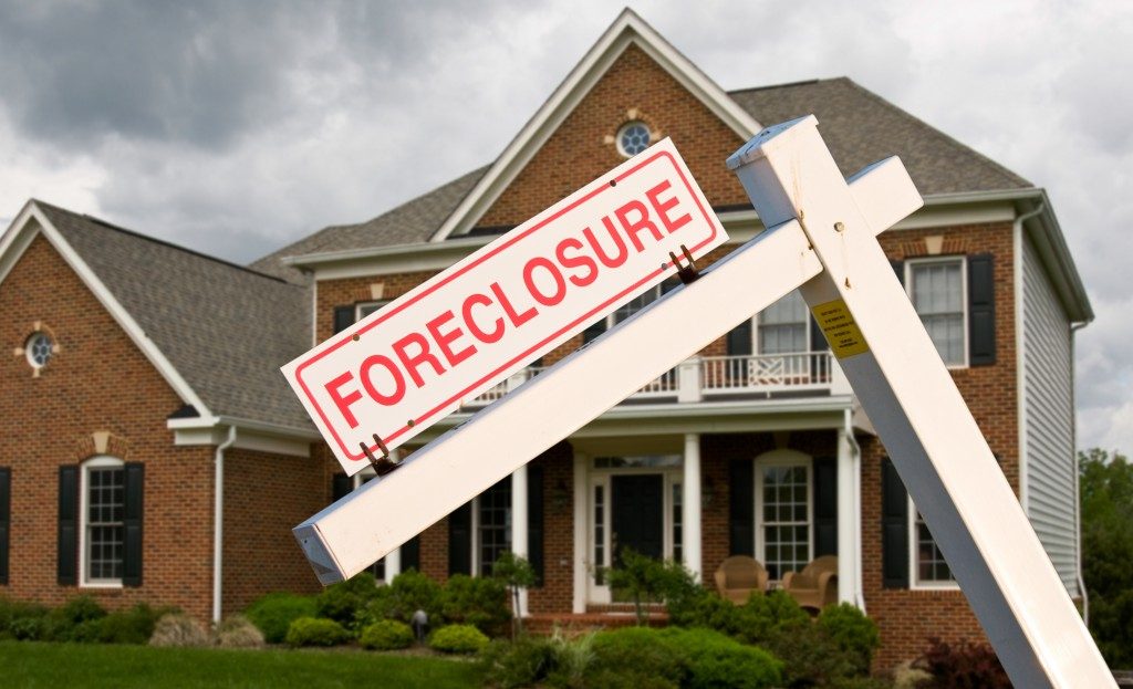 Leaning foreclosure sign in front of house