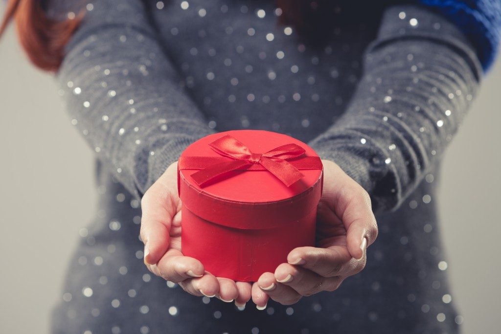gift box cradled in the cupped hands of a woman
