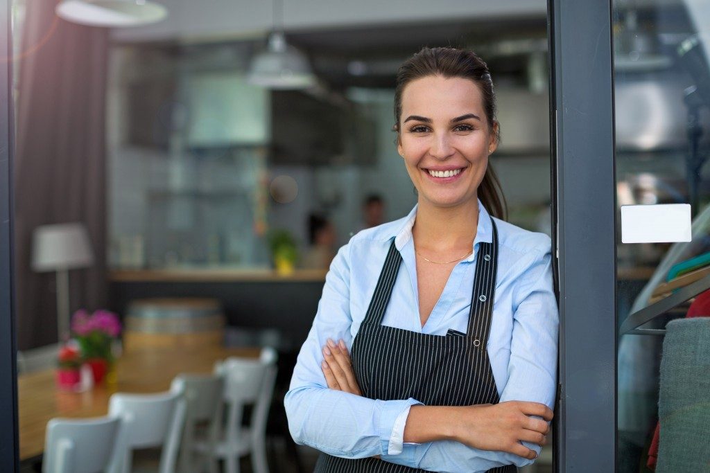 Restaurant owner posing with her arms crossed