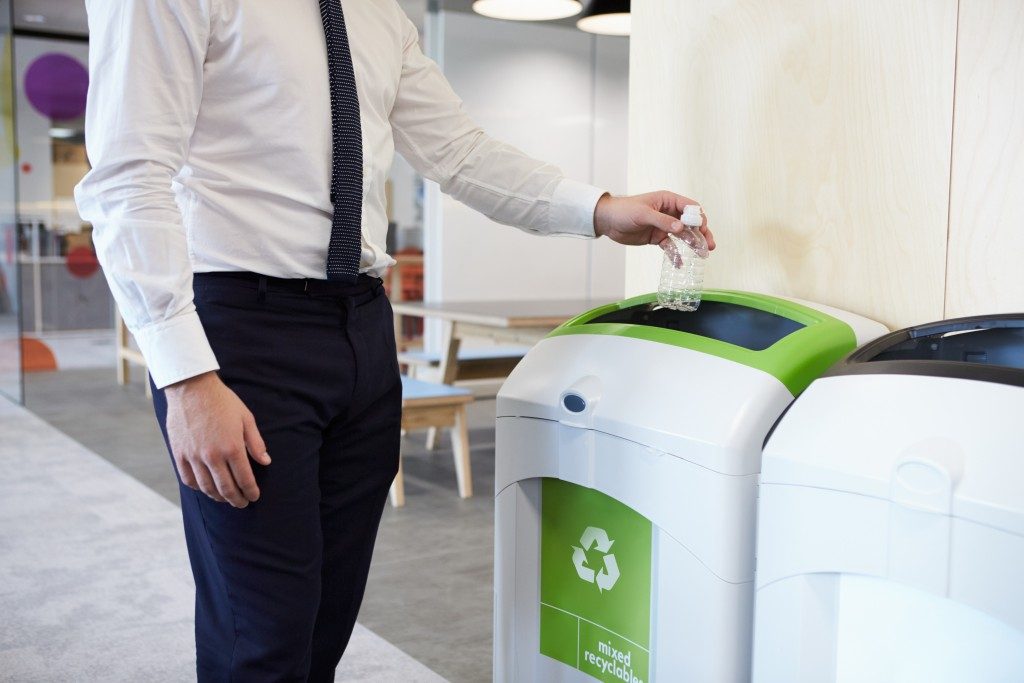 man throwing trash in the recycling bin