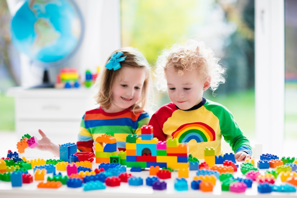 Two kids playing with colorful Legos